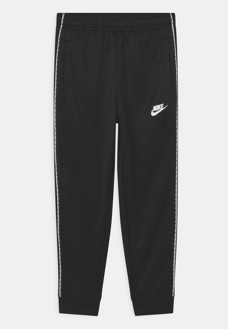 Pantalons de survêtement noirs Nike avec une taille élastique, poches latérales, logo blanc sur la cuisse gauche et rayures blanches à motifs le long des jambes.