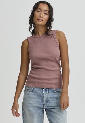 Haut sans manches côtelé de couleur rose poudré avec "BALL" brodé en rose plus clair. Associé à un jean taille haute bleu clair.