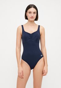 Maillot de bain une pièce bleu marine avec larges bretelles, détail froncé à l'avant et jambes échancrées. Fabriqué en tissu extensible au toucher doux. Logo Speedo.
