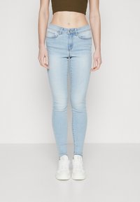 Világoskék, skinny fazonú farmernadrág, közepes derékmagassággal, övakasztókkal, elülső zsebekkel, valamint cipzáras és gombos záródással.