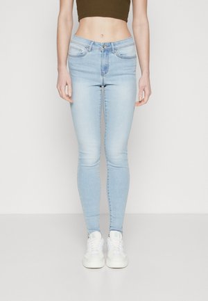 Lyseblå skinny jeans laget av denim, med medium høyt liv, beltehemper, frontlommer og glidelås- og knappelukking.