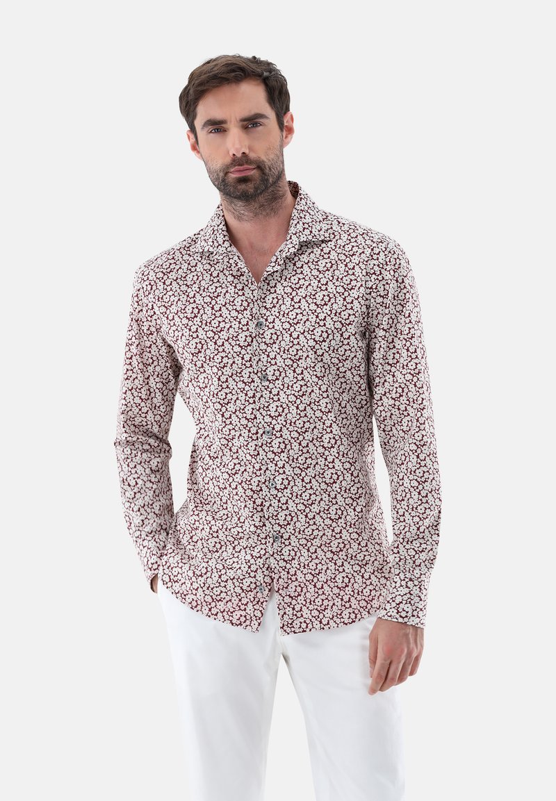 Langarmshirt in Weiß mit rotem Blumendesign. Es verfügt über eine Knopfleiste und einen klassischen Kragen. Der Stoff wirkt leicht und glatt.
