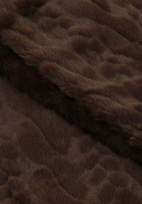 Morbido tessuto in pelliccia trapuntata marrone scuro con un delicato motivo a onde e pieghe sovrapposte.