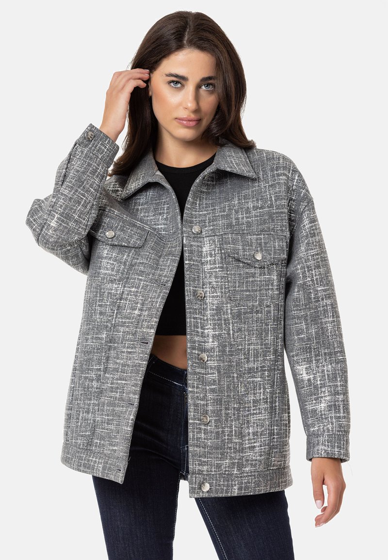 Graue gemusterte Oversized-Jacke mit Knopfleiste, zwei Brusttaschen und Kragen. Der Stoff ist strukturiert und gewebt.