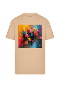 Tricou bej cu mânecă scurtă, prezentând o lucrare abstractă cu pătrate colorate în roșu, albastru, portocaliu și galben, afişată pe partea din față.