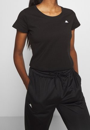 Sort bomulds t-shirt med rund halsudskæring og korte ærmer, parret med sorte bukser med elastisk talje og en diskret logoaccent.