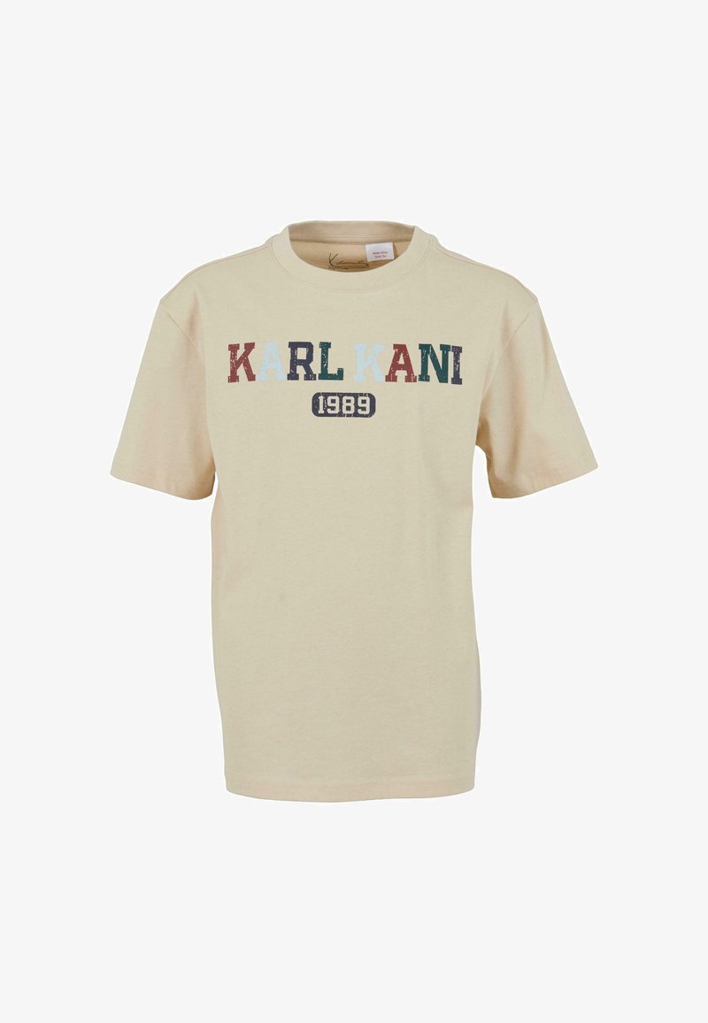 Beež lühikeste varrukatega t-särk, mille ees on mitmevärviliste tähtedega tekst "KARL KANI" ja allpool trükitud number "1989".