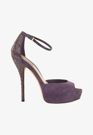 Sandalia de plataforma con tacón alto en color morado, con correa en el tobillo y piedras brillantes en el talón y la parte superior trasera.