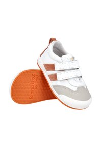 Zapatillas blancas y grises con acentos naranjas, que cuentan con tiras de velcro y una suela texturizada. Material suave con un diseño de punta redondeada.