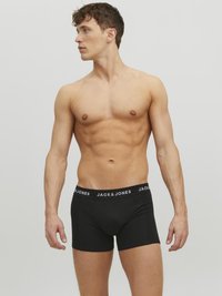 Schwarze Baumwollboxershorts mit einem Logo-Bund, auf dem "JACK & JONES" in weißer Schrift steht. Der Stoff wirkt glatt und enganliegend.