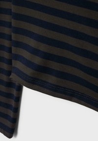 Tekstylia w paski z ciemnozielonymi i granatowymi poziomymi pasami. Materiał wydaje się miękki o gładkiej fakturze, z widocznym przeszyciem.