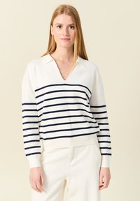 Weißer V-Ausschnitt-Pullover mit marineblauen horizontalen Streifen. Hat lange Ärmel, einen Kragen und gerippte Bündchen sowie Saum. Weicher Stoff.