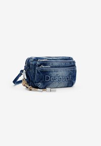 Denim Umhängetasche mit zwei Reißverschlussfächern, hellblauer Farbe, strukturiertem Stoff und geprägtem "Desigual"-Logo auf der Vorderseite.