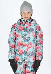 Colorful, mint-green jacket with a flamingo and leaf pattern, featuring a hood and black accents. Model wears a grey beanie and black gloves.