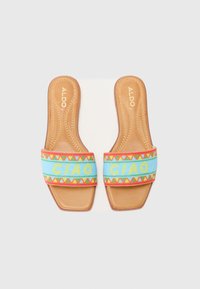 Sandales plates avec une semelle synthétique beige, dotées d'une bride en tissu bleu tissée avec des motifs géométriques colorés et le texte "CIAO".