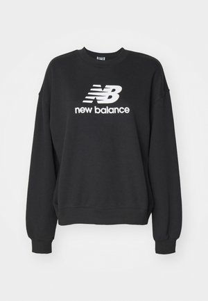 Črna majica s kapuco iz bombaža, s krojenim ovratnikom, spuščenimi rameni in belim logotipom "new balance" spredaj. Mehka tekstura.