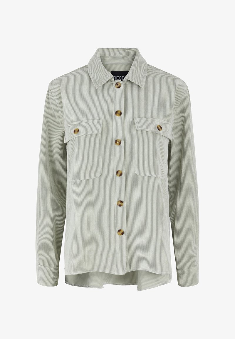 Veste chemise en velours côtelé vert clair avec fermeture à boutons, deux poches poitrine et un ourlet légèrement arrondi. Elle présente de grands boutons ronds et un col.
