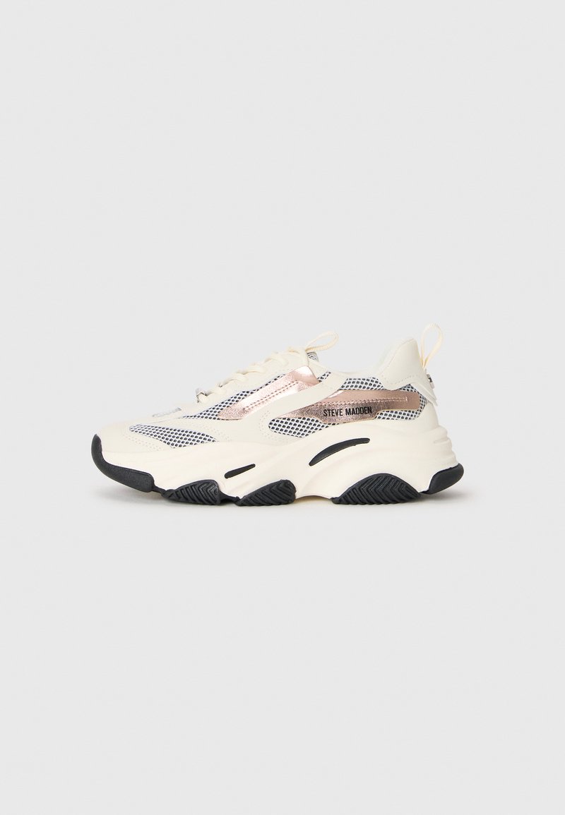 Basket de sport chunky blanche avec semelle noire, panneaux en maille et accents en or rose, étiquetée "Steve Madden" sur le côté.