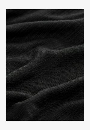 Černá látka s hladkým, mírně strukturovaným povrchem, s jemnými vlnkami a záhyby. Materiál vypadá lehký a prodyšný.