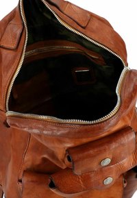 Zaino in pelle marrone con apertura a cerniera, cuciture visibili, fodera interna camouflage e due tasche frontali con chiusura a scatto.