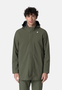 Giacca da pioggia verde impermeabile con colletto alto e cappuccio regolabile. Presenta un design elegante e minimale e un logo sul petto.