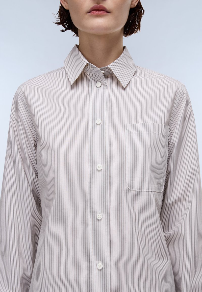 Striped button-up shirt featuring a soft fabric in beige and white, a classic collar, and a chest pocket, showcasing a straight cut.