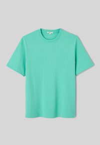 T-shirt turquoise uni à manches courtes avec col rond, posé à plat sur un fond gris clair.