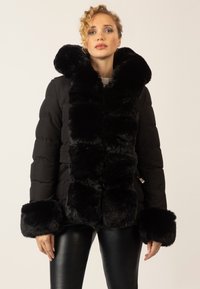 Schwarze Daunenjacke mit großem Kunstfellkragen und -manschetten, Reißverschluss und tailliertem Gürtel. Texturierter Stoff mit einem plüschigen Aussehen.