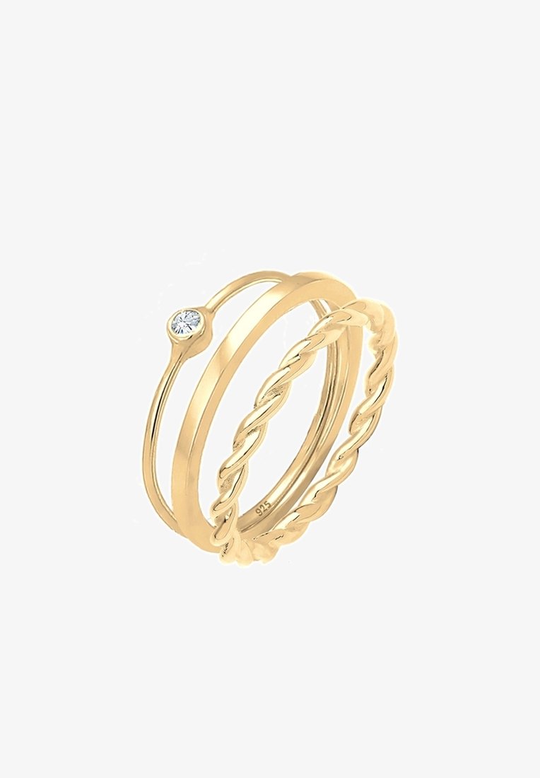 Trois bagues en or avec des designs différents : une torsadée, une simple et une fine avec un petit diamant rond.