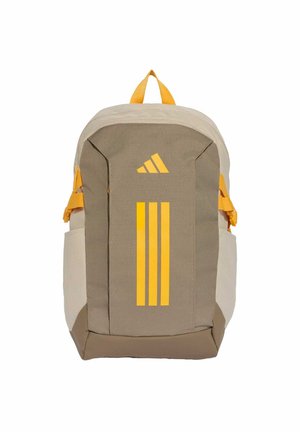 Sac à dos beige et marron avec logo et bandes jaunes Adidas, poches latérales et poignée supérieure sur fond blanc.