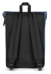 Zaino nero e blu con una finitura testurizzata, spallacci imbottiti, manico superiore e chiusura con zip. Presenta una forma rettangolare slim.