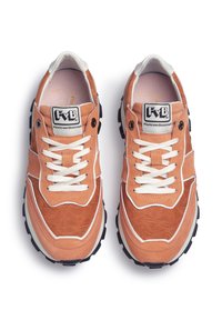 Orangene Wildleder- und Textilsneaker verfügen über weiße Schnürsenkel, ein welliges Muster und eine schwarze Gummisohle. Logo auf der Zunge sichtbar.