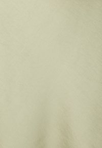 Gaiši bež audums ar mīkstu, teksturētu virsmu un smalku spīdumu, kam ir vienota krāsa bez redzamām rakstiem vai akcentiem.
