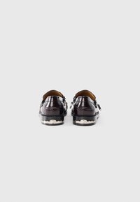 Pantofi din piele de culoare violet închis, cu o finisare lucioasă, cusături decorative și un detaliu texturat argintiu pe talpă, dotati cu o închidere clasică cu cataramă.
