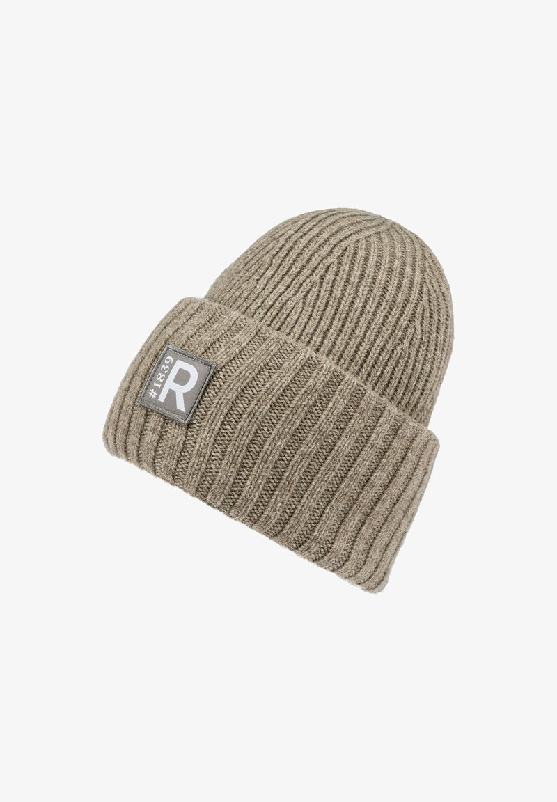 Knit beanie in light brown with ribbed texture, featuring a gray rectangular patch with white text and logo on the front.