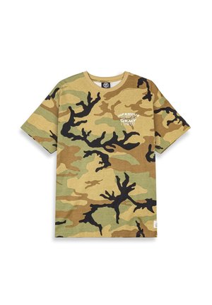Camiseta de algodón en un patrón de camuflaje que presenta tonos de verde, marrón y negro, con un logo impreso en blanco en el pecho. Diseño de cuello redondo.