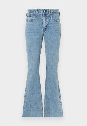 Svetlo modre jeans hlače zvonaste oblike z visokim pasom, ki imajo sprednjo zapenjanje na gumbe, pet žepov in subtilno sabljanje na stegnih.