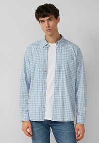 Lichtblauw geruit shirt met button-down kraag, lange mouwen, witte knopen, enkele borstzak, gedragen over een wit T-shirt.