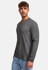 Szary longsleeve henley wykonany z miękkiego materiału, z okrągłym dekoltem i trzema drewnianymi guzikami z przodu.