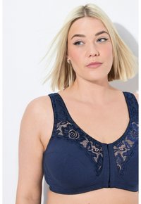 Sujeción de navy con detalles de encaje floral, tirantes anchos y cierre frontal. Tela suave con un toque de encaje texturizado en la parte superior.