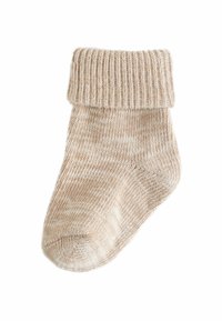 Stricksocke in hellem Beige mit geripptem Bund und glattem Körper, ausgestattet mit einer subtilen wellenartigen Textur und einer runden Zehenpartie für zusätzlichen Komfort.
