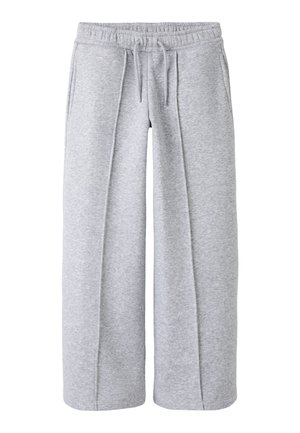 Pantalon de survêtement large gris clair avec taille élastique et cordon, avec poches latérales et plis à l’avant.