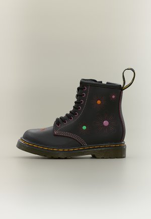 Μαύρο δερμάτινο μποτάκι με κορδόνι, ραφή κίτρινου χρώματος στη σόλα, floral σχέδια περιγράμματος και πολύχρωμες στρογγυλές διακοσμήσεις στο πλάι και στα δάχτυλα.