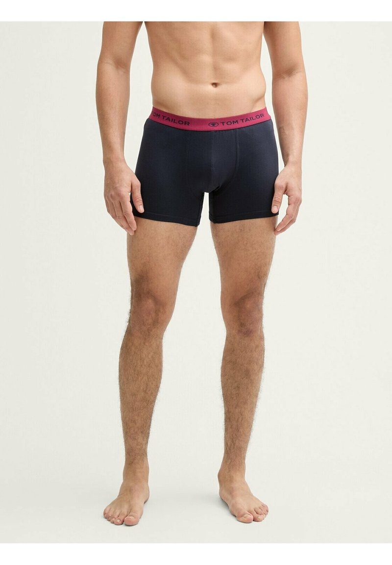 Boxer neri con una ampia cintura rosa scuro e il logo "TOM TAILOR". Il tessuto appare liscio ed elasticizzato, offrendo un design aderente.