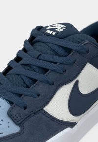 Adidașii Nike SB Force 58 au un superior din suede albastru închis, o limbă din plasă, accente subtile de albastru deschis, o talpă intermediară albă și un logo distinctiv pe limbă.