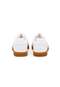 Weiße Ledersneaker mit glänzender Oberfläche, ausgestattet mit einer Gummisohle und minimalistischem Design. Die Rückansicht zeigt ein unauffälliges Logo-Detail.