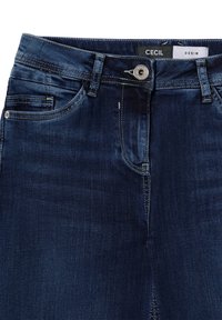 Jean en denim bleu foncé avec un design classique à cinq poches, bouton en métal argenté et détails de couture le long des poches et des coutures.