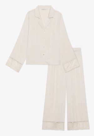 Helle beige Schlafanzugset bestehend aus einem Hemd mit Knopfleiste und Spitzenbündchen sowie passenden weiten Hosen. Weicher Stoff mit glatter Textur.