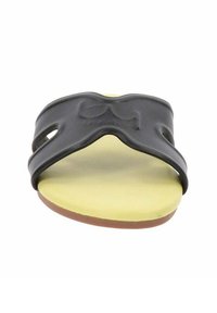 Sandal in sintetico nero con soletta gialla, dotato di un design della cintura sagomato e texture liscia. La suola ha una base piatta in gomma marrone.