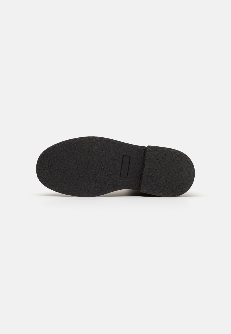 Schwarze Schuhsohle mit einer strukturierten, gummiartigen Oberfläche. Verfügt über ein flaches Profil und einen leichten Absatz, mit einem verstärkten Rand für Langlebigkeit.
